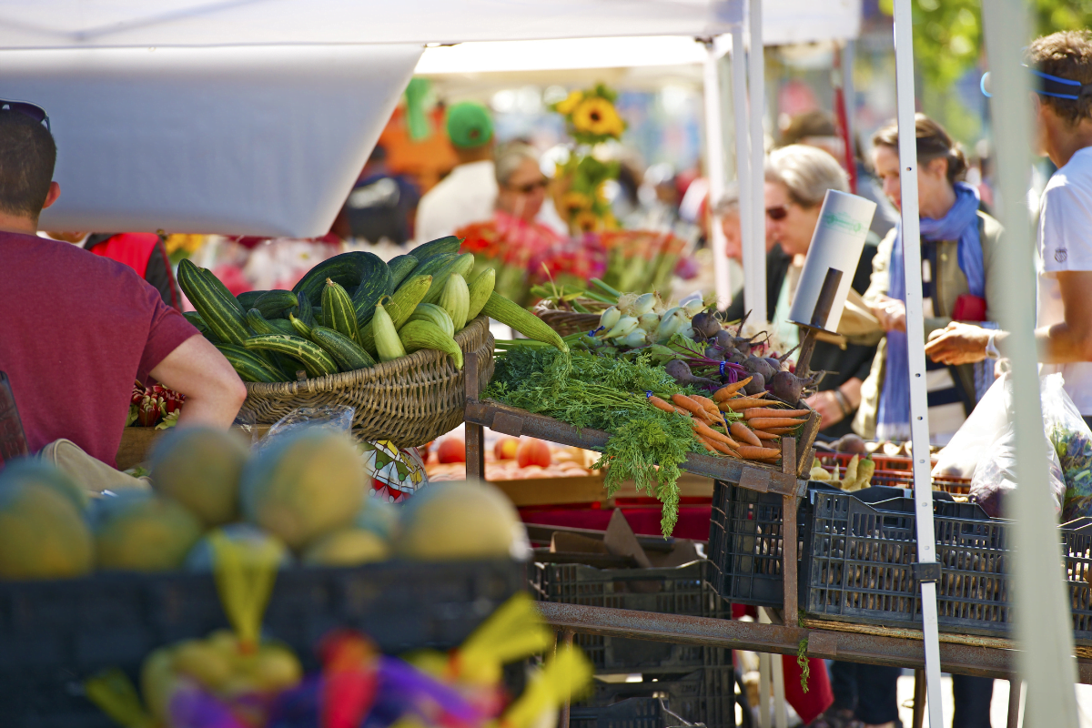 Farmers market with vegetables and fruit at the fore front